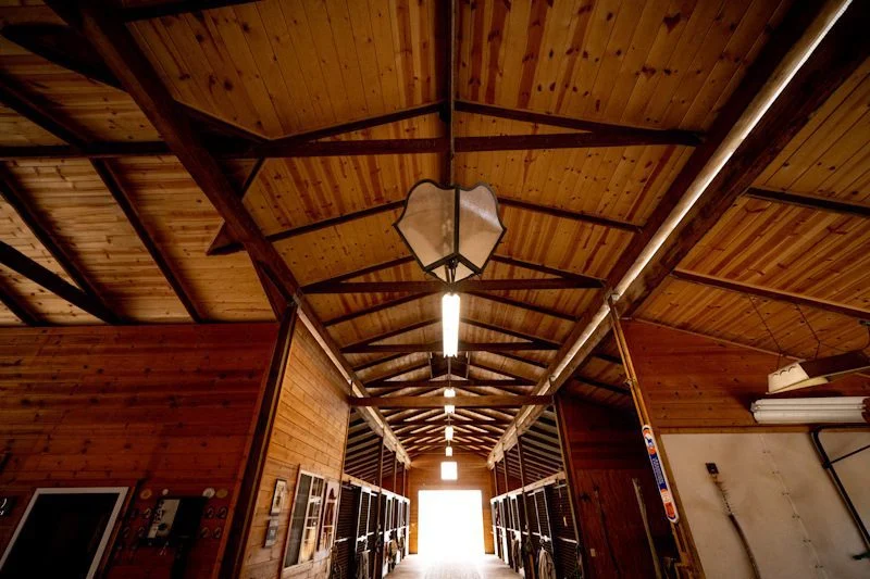 Wood-lined aisle of the 16-stall barn at Jaz Creek