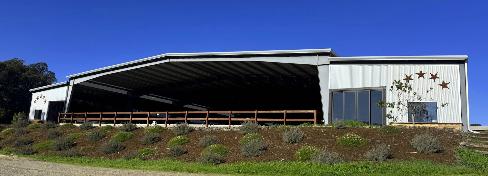 Jaz Creek covered arena with landscaped hillside in front